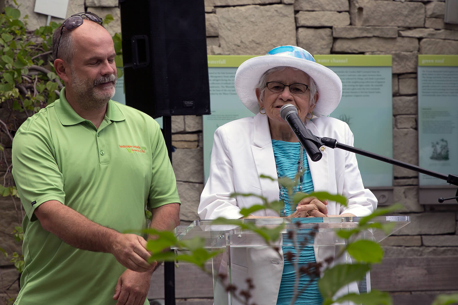 man and a woman at a podium outside