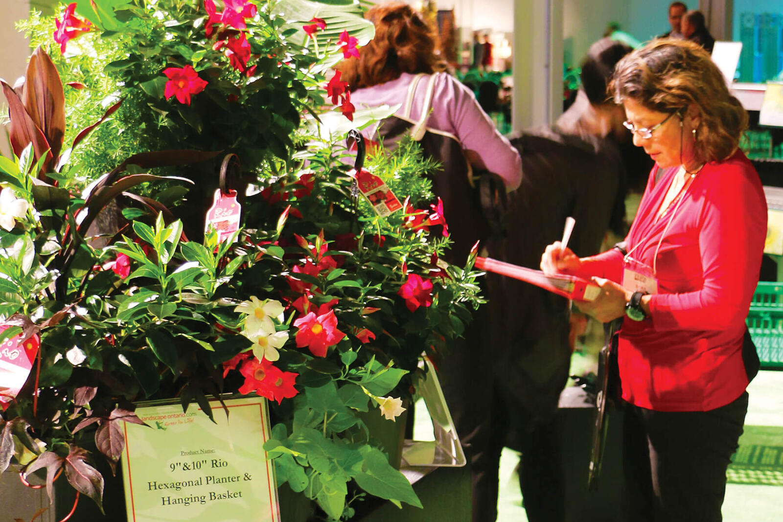 woman with a clipboard evaluating a large floral display