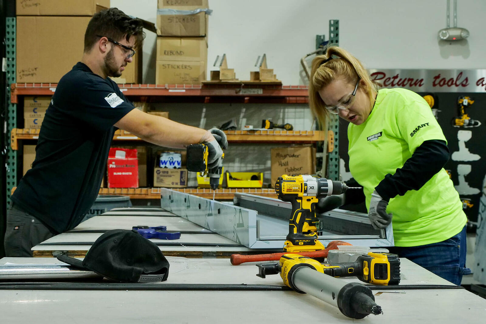 man and woman building something on a workbench